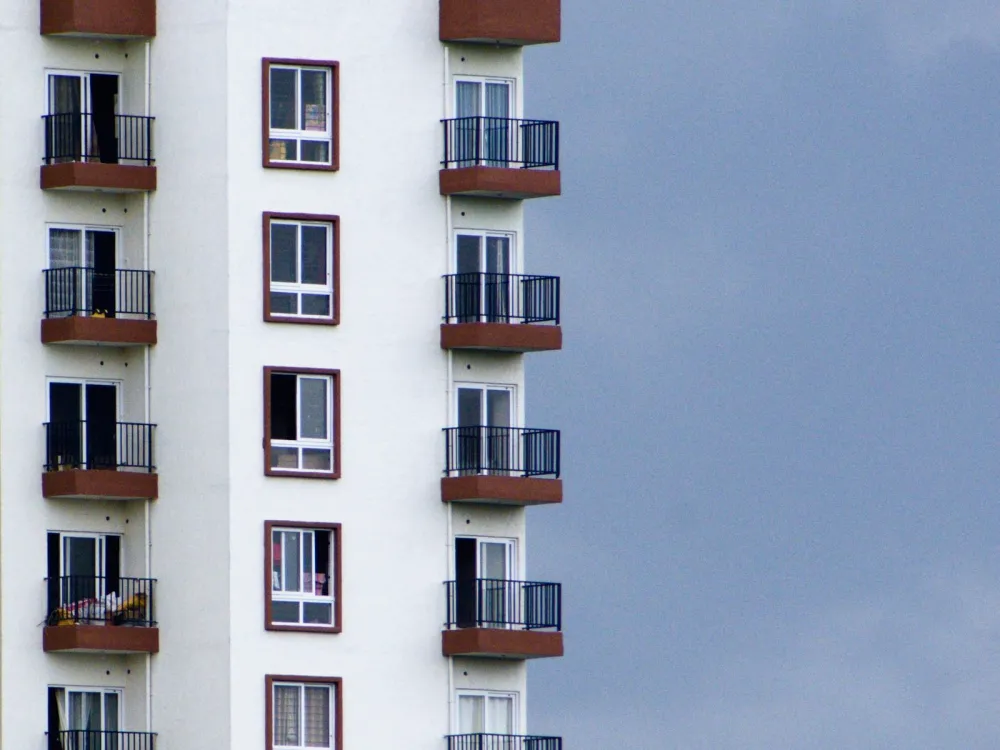 Apartment tower with balconies against a blue sky